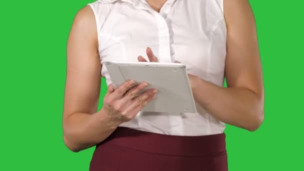 Mujer sosteniendo la tableta digital y usarlo mientras camina en una pantalla verde, Chroma Key . — Vídeo de stock