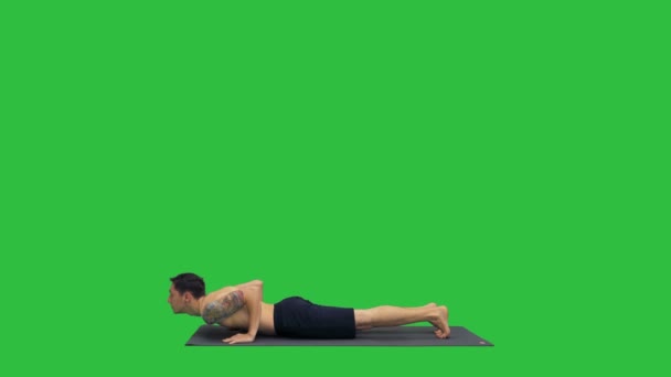 Knappe man doen yoga asana's op een groen scherm, Chromakey. — Stockvideo