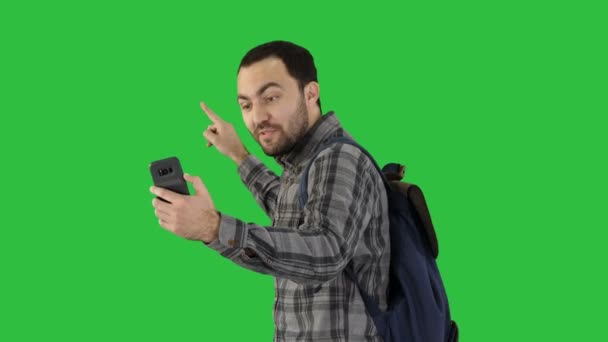 Pessoas, estilo de vida, natureza e conceito de aventura Elegante jovem viajante com mochila segurando smartphone e atirando em si mesmo, gravando relatório de vídeo de sua jornada para seu blog em uma tela verde — Vídeo de Stock