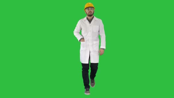 Modern young phisicist walking and reading message on phone on a Green Screen, Chroma Key. — Stock Video