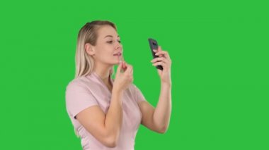 Güzellik, insanlar, makyaj, Genç kadın akıllı telefondaki Chroma anahtar yeşil ekranda Looking dudakları.