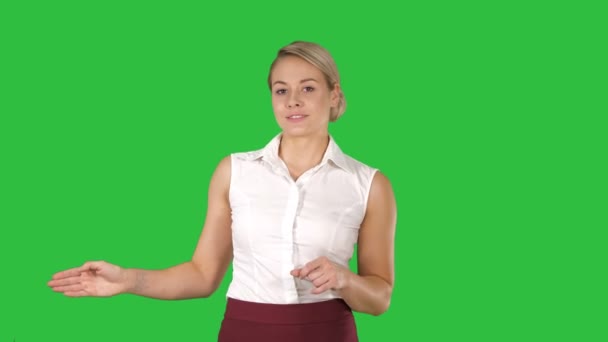 Kobieta idzie Blondynka i mówić do kamery, wskazując na boki na zielony ekran, Chroma Key. — Wideo stockowe