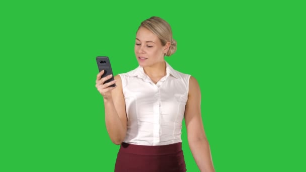 Νεαρή γυναίκα ψάχνει στο smartphone σκέψης και ανάγνωση σε μια πράσινη οθόνη, Chroma Key. — Αρχείο Βίντεο