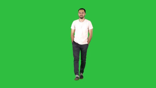 Hombre adulto joven confiado caminando hacia adelante y mirando a la cámara en camisa blanca en una pantalla verde, Chroma Key . — Vídeo de stock