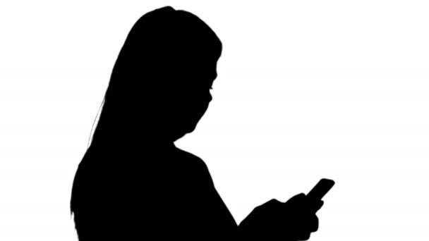 Silhouette Retrato de la joven alegre enviando un mensaje en el teléfono inteligente . — Vídeos de Stock