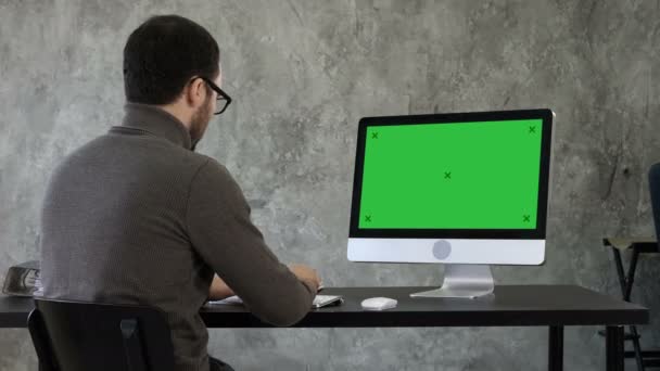 Un giovane uomo d'affari barbuto che si agita al computer. Visualizzazione finto schermo verde . — Video Stock