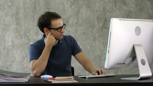 Unatkozó fiatalember az íróasztalnál számítógép előtt. — Stock videók