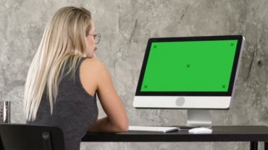 Kadın, serbest meslek sahibi bilgisayar monitörü arıyorum. Yeşil perde Mock-up göstermek.