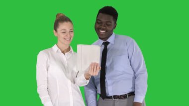 Genç beyaz işkadını ve onun Afrika meslektaşım Chroma anahtar yeşil ekran tablet ile görüntülü arama yapma.