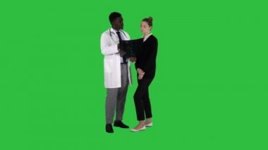 Genç kadın ziyaret radyolog x-ray sınav üstünde a yeşil perde, Chroma Key beyninin için.