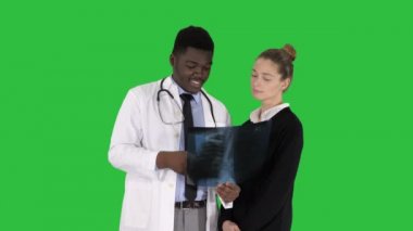 Orta atış. Doktor hastanın göğüs röntgeni Chroma anahtar yeşil ekran gösterir. 4 k çözünürlüklü profesyonel vurulmuş. 012. Örneğin kullanabilmeniz için ticari video, tıbbi, iş, tanıtım