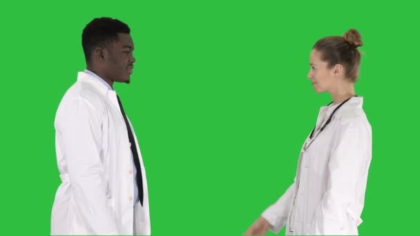 Dos médicos jóvenes estrechando las manos en una pantalla verde, Chroma Key . — Vídeos de Stock