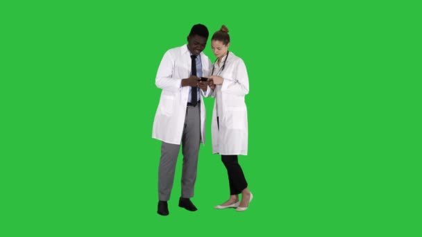 クロマキー グリーン画面で一緒に携帯電話を見て医療チーム. — ストック動画
