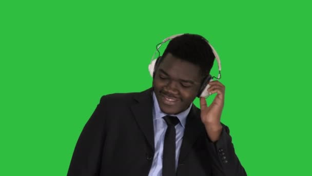 Homme d'affaires noir dansant sur la musique dans les écouteurs sur un écran vert, Chroma Key . — Video