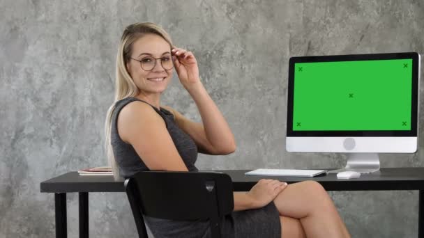 Mooie business lady in kantoor is camera kijken en glimlachen. Groen scherm Mock-up Display. — Stockvideo