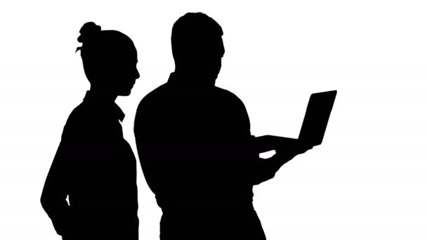 Silhouet Tevreden over hun werk man en vrouw op zoek in de laptop. — Stockvideo