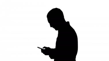 Yürüyüş ve dikkatle cep telefonu ekranına bakarak siluet adam doktor. Sonunda şarkı attantion yapma.
