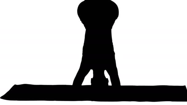 Silhouette Beautiful young woman doing yoga exercise variation of supported headstand, garuda salamba sirsasana with crossed legs. — Stock Video