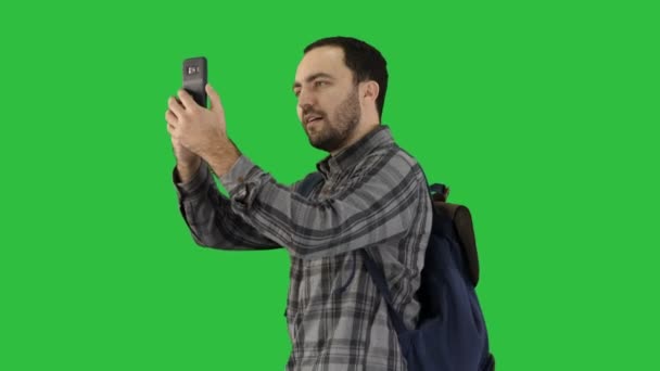 Aantrekkelijke jonge toeristische met rugzak wandelen en het gebruik van mobiele telefoon op een groen scherm, Chromakey. — Stockvideo