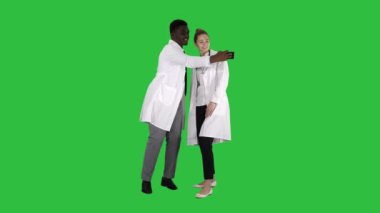 İki doktor bir smartphone kullanarak ve Chroma anahtar yeşil ekran gülümseyen selfie yapıyoruz.