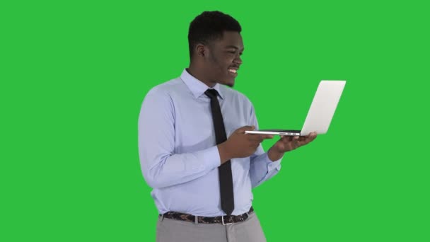 Cheerful successful young African American manager with laptop having video conference call with business partners on a Green Screen, Chroma Key. — Stock Video