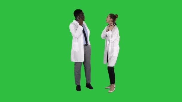 Ärztin und Arzt mit Mobiltelefonen, die auf einem grünen Bildschirm fröhliche Nachrichten verkünden, Chroma-Schlüssel. — Stockvideo