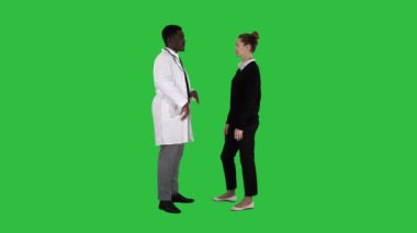 Chroma anahtar yeşil ekranda genç kadına ilaç erkek doktor sunar.