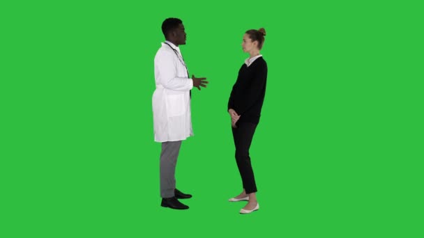 Male african doctor talking to female patient on a Green Screen, Chroma Key. — Stock Video