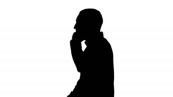 Silhouette Cool νεαρός άνδρας με γενειάδα με τα πόδια και μιλώντας με το κινητό τηλέφωνο. — Αρχείο Βίντεο