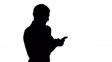 Siluet manifatura arkadaş için. Akıllı telefon tutarak ve gülümseme dururken bakarak çekici genç kadın.