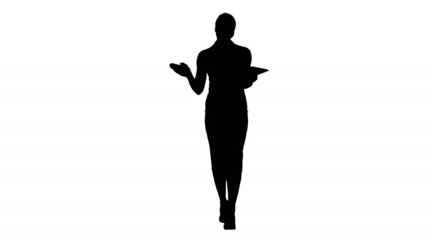 Silhouette Business woman with tablet walking and talking to the camera. — Stock Video