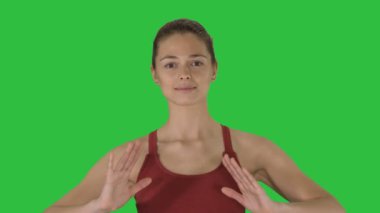 Genç kadının Chroma Key Yoga nefes egzersizleri yeşil bir ekran üzerinde yapması.
