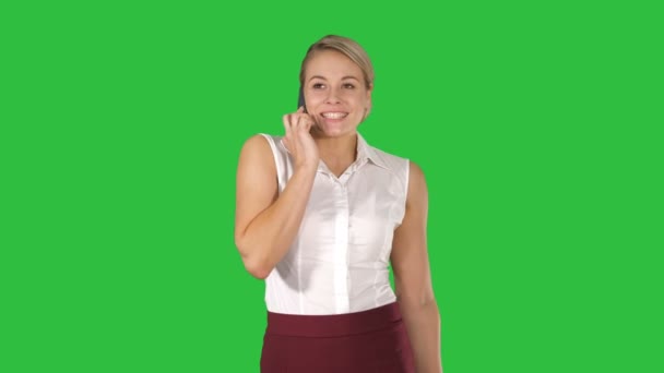 Donna affascinante che chiama con il telefono cellulare mentre cammina su uno schermo verde, Chroma Key . — Video Stock