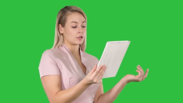 Mujer feliz charlando a través de una videollamada, mediante el uso de una tableta en una pantalla verde, Clave de croma . — Vídeos de Stock