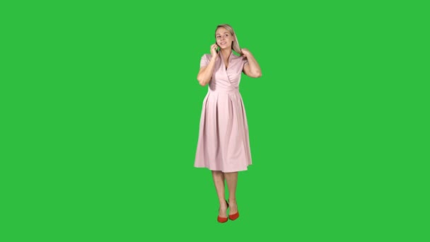 Ευτυχισμένη γυναίκα χαμογελαστή μιλάμε για κινητό τηλέφωνο ενώ περπατούν σε μια πράσινη οθόνη, Chroma Key. — Αρχείο Βίντεο