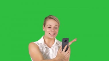 Chroma anahtar yeşil ekran yürüyüş akıllı telefon üzerinde pembe yapmak video seslenmek giyen kadın.