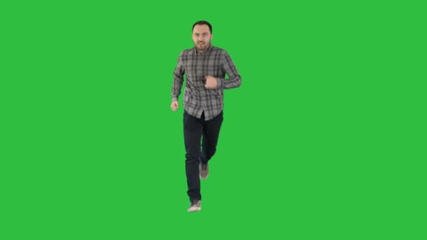 Jonge man loopt opgewonden op een groen scherm, Chromakey. — Stockvideo