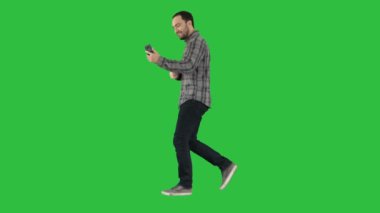 Eğlence, teknoloji, iletişim ve insan kavramı - kullanarak ve yeşil ekranda Chroma Key yürürken Smartphone'da çağıran genç adam.