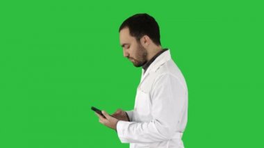 Portre portre yakışıklı erkek sağlık meslek ya da doktor ya da hemşire, Chroma anahtar yeşil ekranda cep telefonuyla mesaj.