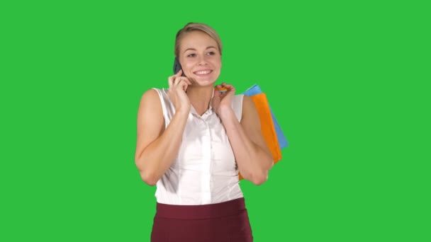 Shopper mujer llamando con el teléfono inteligente sosteniendo bolsas de compras y caminando en una pantalla verde, Chroma Key . — Vídeo de stock