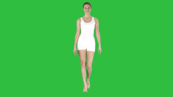 Dame, die in weißen Sportunterwäsche auf einem grünen Bildschirm läuft und lächelt, Chroma-Schlüssel. — Stockvideo