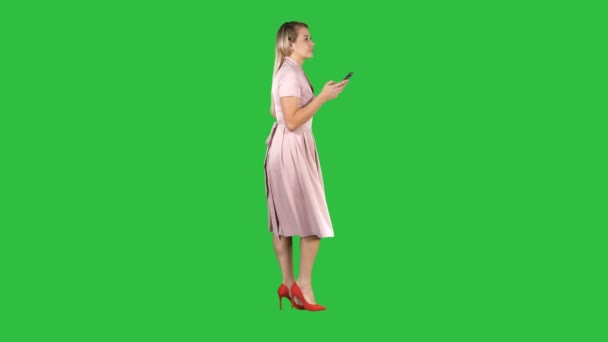 Blonde žena používající mobilní telefon SMS zprávy na zelené obrazovce, Chroma Key. — Stock video