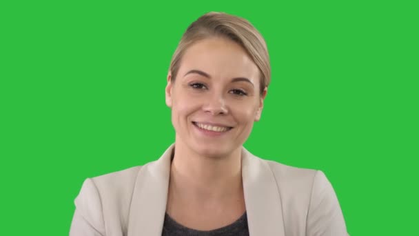 Gelukkig jonge vrouw in formele kleding kijken van de camera met glimlach op een groen scherm, Chromakey. — Stockvideo