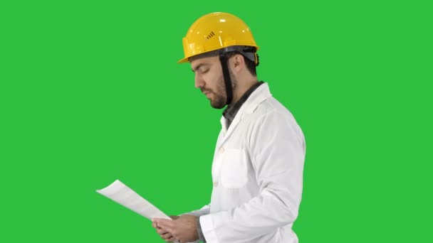 Engenheiro contratado andando com papéis e verificando arround em uma tela verde, Chroma Key . — Vídeo de Stock