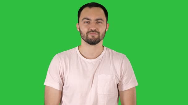 Giovane uomo felice in t-shirt sorridente alla fotocamera e camminare su uno schermo verde, Chroma Key . — Video Stock