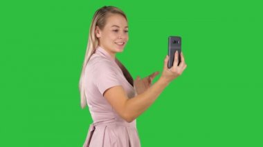 Orta yan görünüm vurdu. Chroma anahtar yeşil ekran akıllı telefonu ile video arama yapma pembe elbiseli kadın. 4 k çözünürlüklü profesyonel vurulmuş. 005. sen-ebilmek kullanma o bir örneğin içinde ticari video