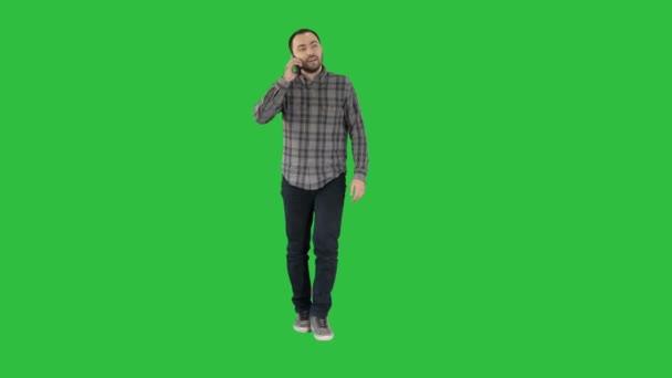 Walking man is talking on the phone and smiling on a Green Screen, Chroma Key. — Stock Video