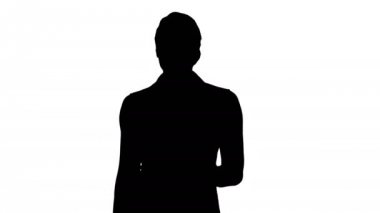 Siluet Formaly giyinmiş genç kadın kameraya doğru yürüyor..