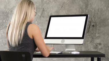 Office masaüstü monitör çalışma masasında oturan işkadını. Beyaz ekran.