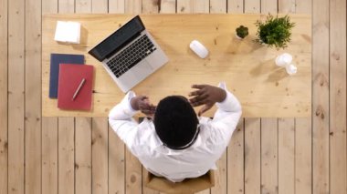 Üstten görünüm. Çünkü çaresiz ve stresli baş ağrısı acı genç Afro-Amerikan Doktor ağrı ve migren. Ellerini başını üzerine koy. 4 k çözünürlüklü profesyonel vurulmuş. 017. sen-ebilmek kullanma o örneğin,